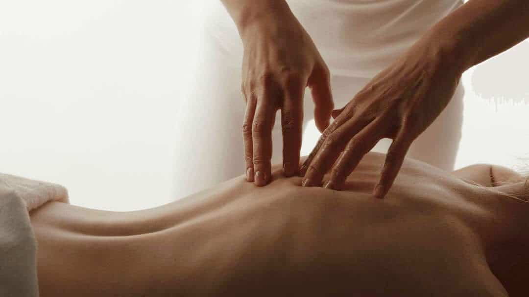 Hands massaging the back of a woman