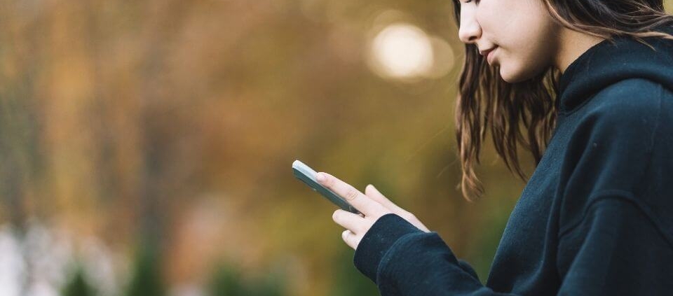 Teenager hält ein Smartphone