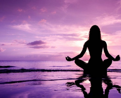 Femme en position de yoga au bord de la mer