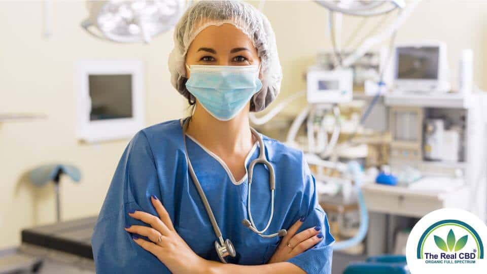 A nurse with a mask on standing in an operating room