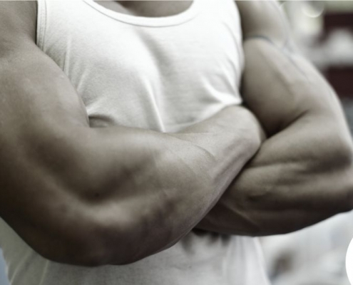 Homme musclé en t-shirt blanc, croisant les bras