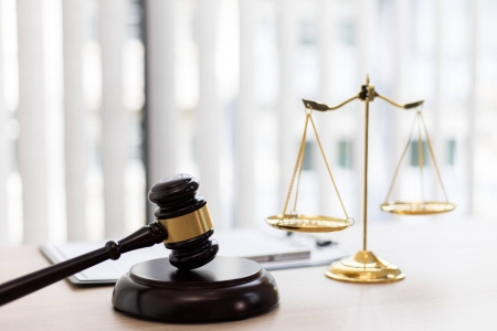 Judge's hammer and antique weight scale on a table-top