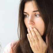 Woman looking troubled at a hairbrush full og hair