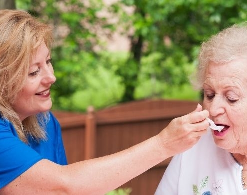 Caretaker feeding an elderly lady