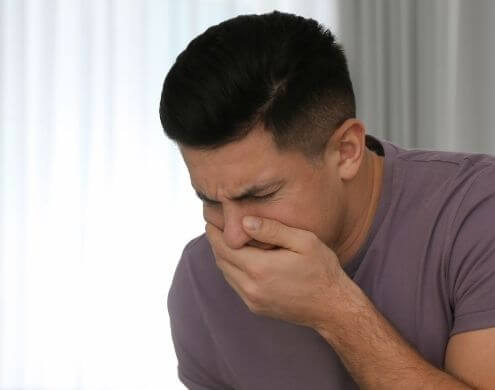 Man with nausea holding his mouth