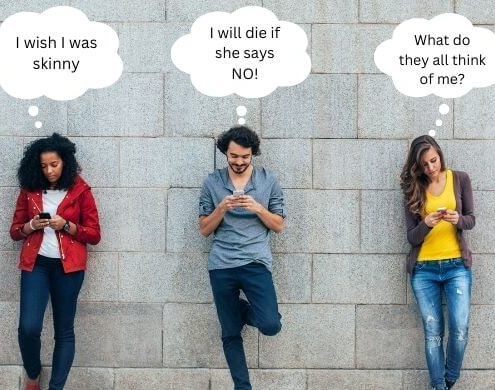 Teenagers on their smartphones up against a brick wall