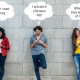 Teenagers on their smartphones up against a brick wall