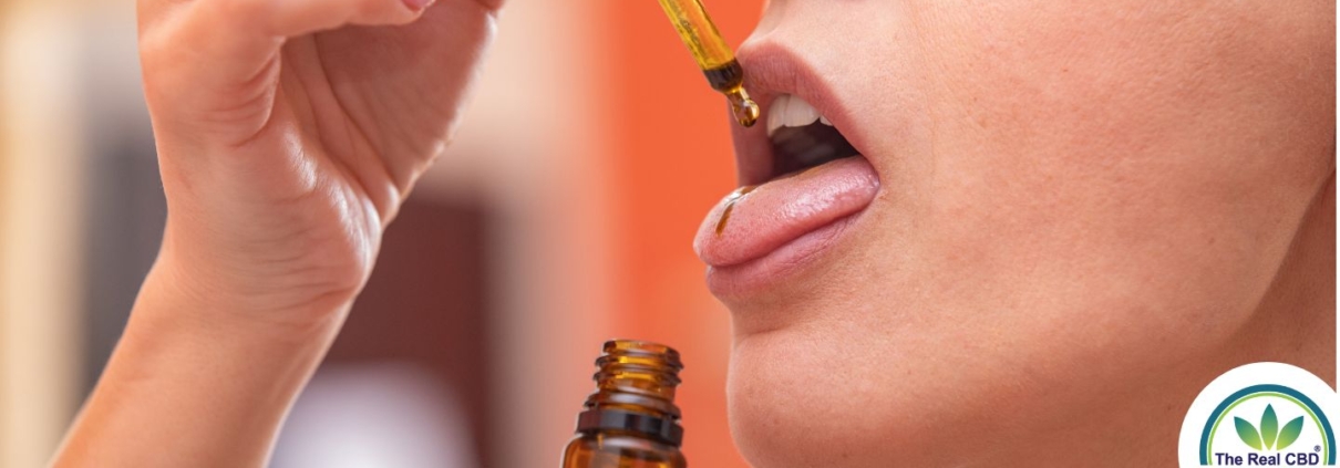 Woman taking CBD oil on the tongue