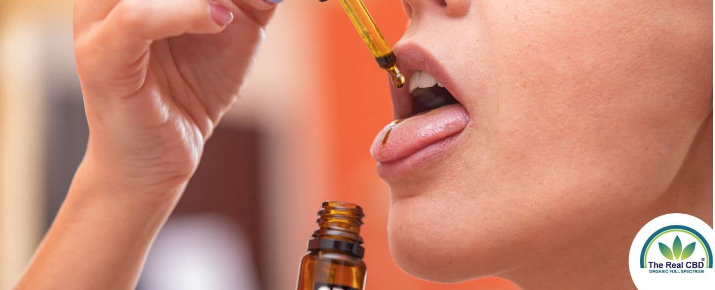 Woman taking CBD oil on the tongue