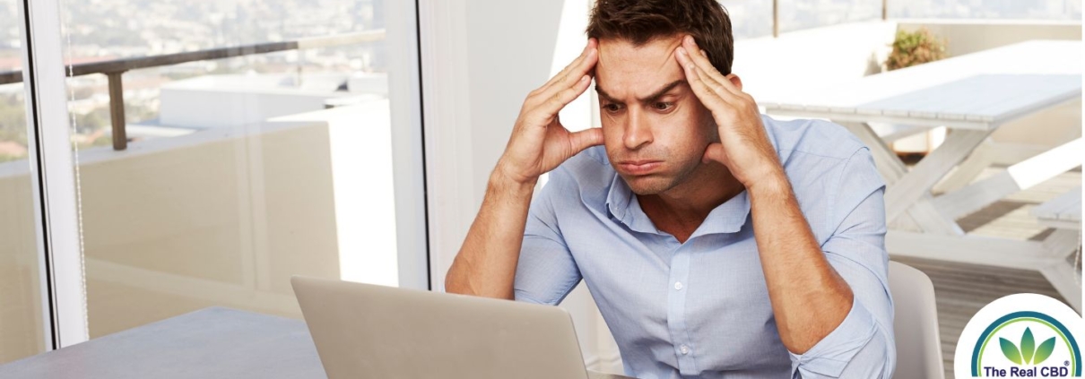 Homme regardant avec frustration l'écran d'un ordinateur portable