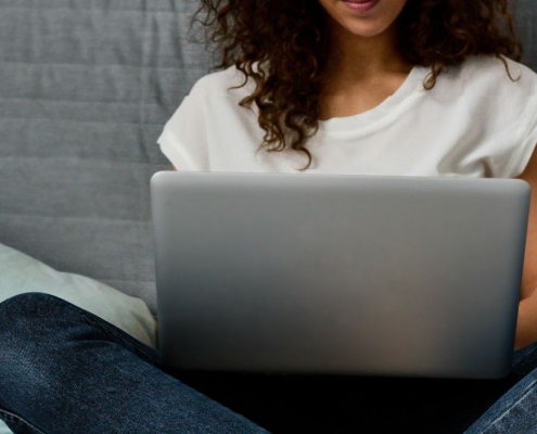 Teen working on a laptop in bed