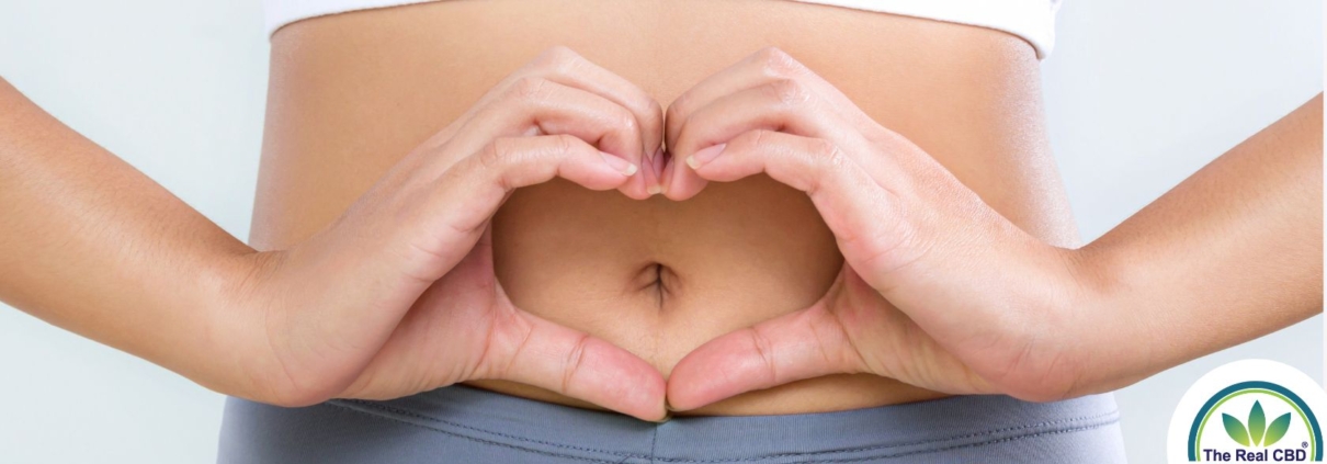 Woman making heart shape with her hands in front of her bellybutton