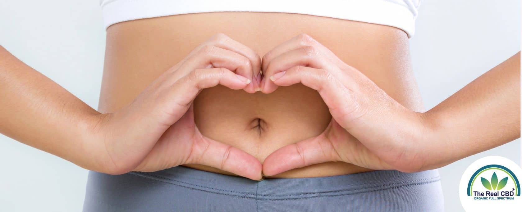 Woman making heart shape with her hands in front of her bellybutton