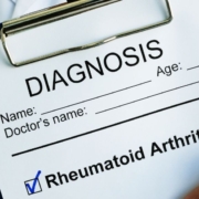 Arzt hält Klemmbrett mit rheumatoider Arthritis Diagnose auf