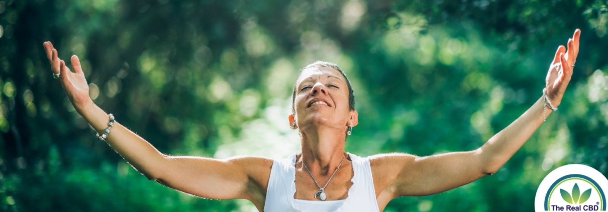 Femme heureuse ouvrant les bras dans une forêt