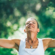 Femme heureuse ouvrant les bras dans une forêt