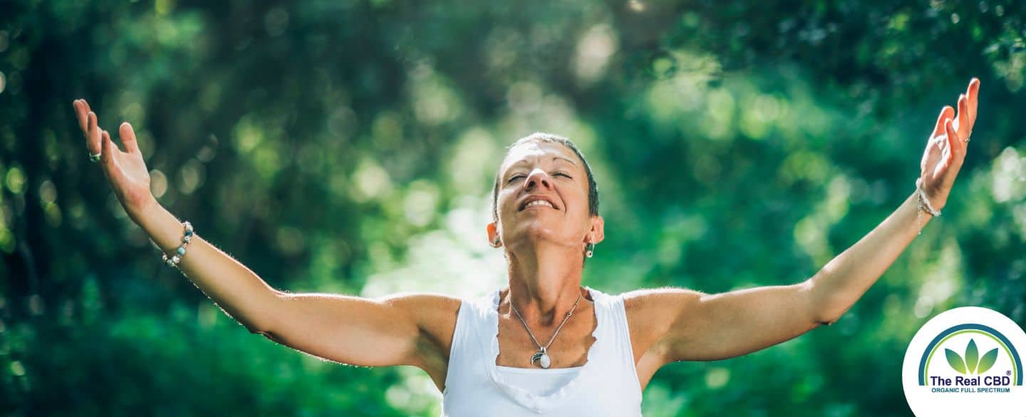 Femme heureuse ouvrant les bras dans une forêt