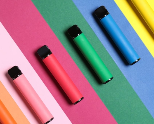 Multicoloured vape pens on a stripy matching background