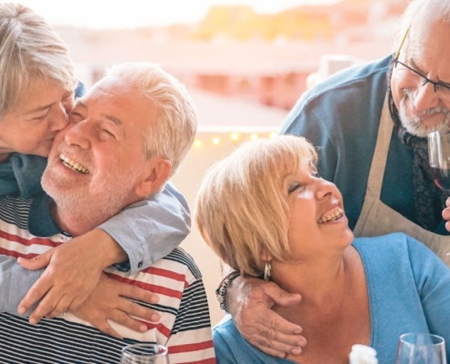 Two middled couples having a good time drinking wine at a BBQ