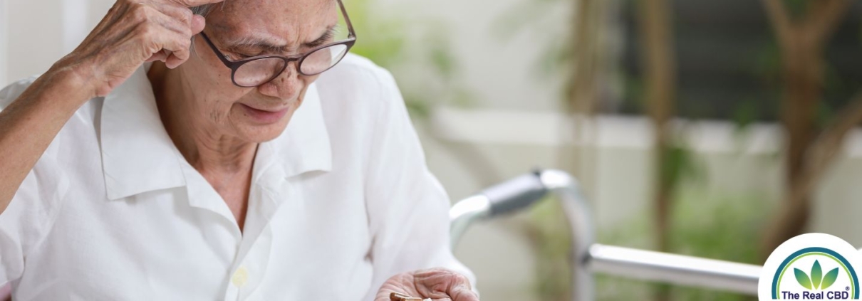 Elderly person looking confused at tablets in hand