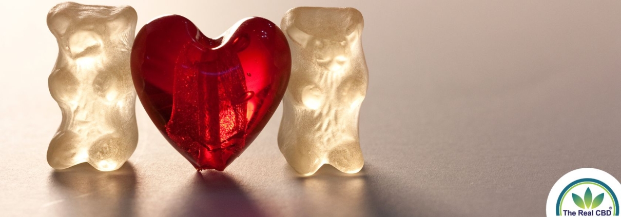 Two white gummy Bears with a red gummy heart in-between