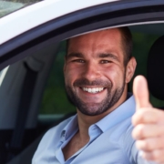 Un homme lève le pouce dans une voiture