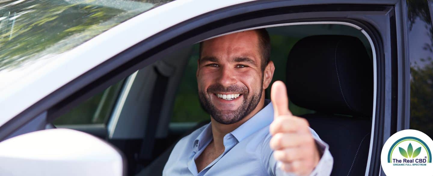 Un homme lève le pouce dans une voiture