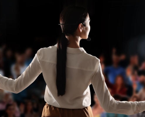 Woman on stage speaking to a crowd