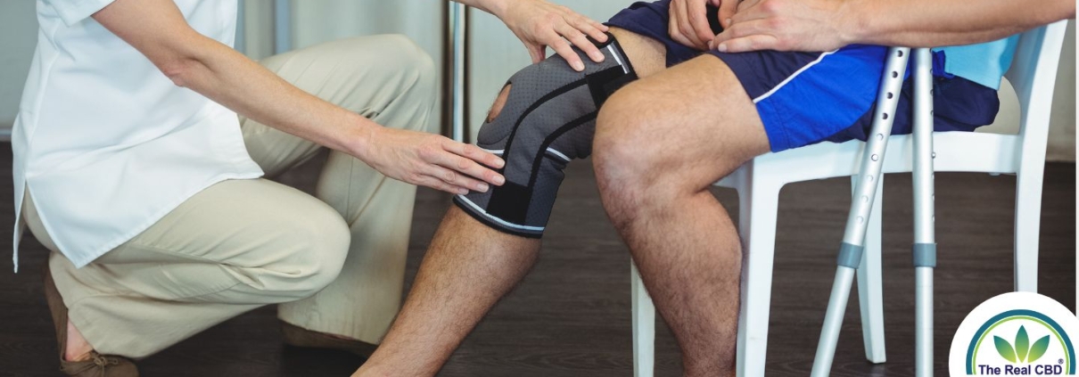 Nurse holding sick knee on patient sitting down