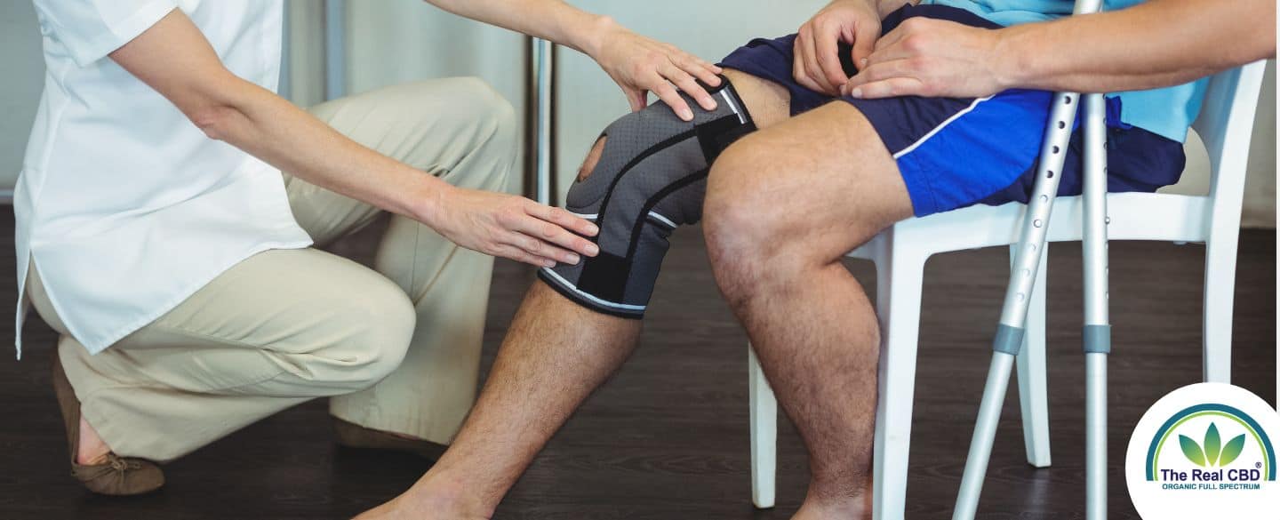 Nurse holding sick knee on patient sitting down