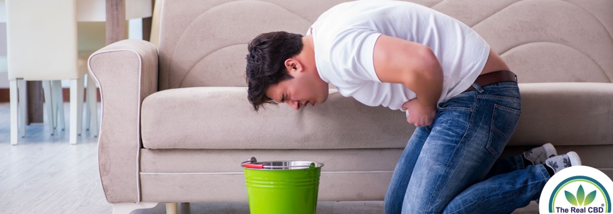 Man bent over a bucket ready to puke