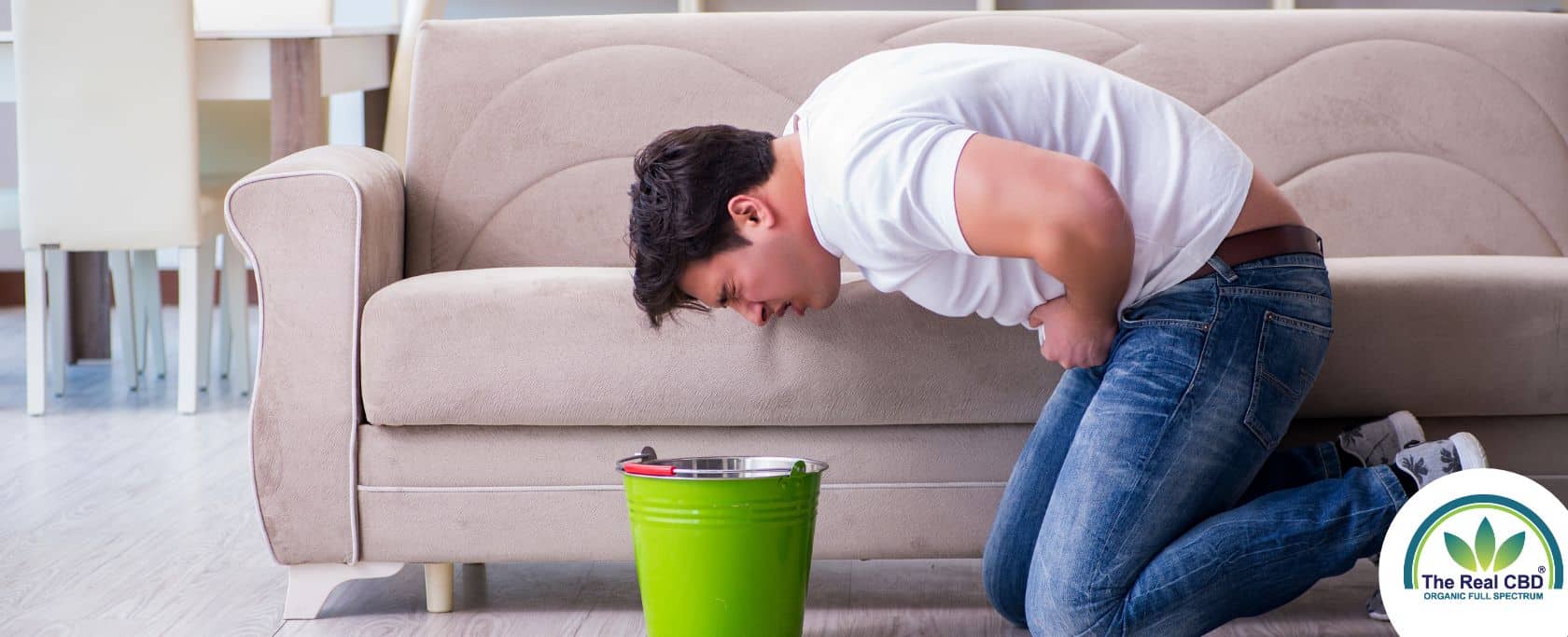 Man bent over a bucket ready to puke