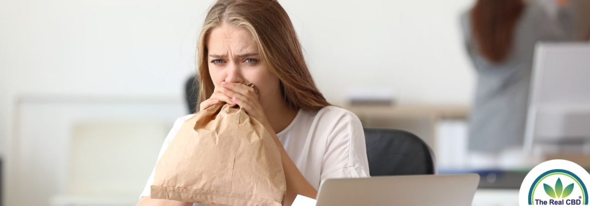 Femme soufflant dans un sac en papier dans un bureau