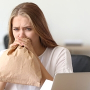 Femme soufflant dans un sac en papier dans un bureau