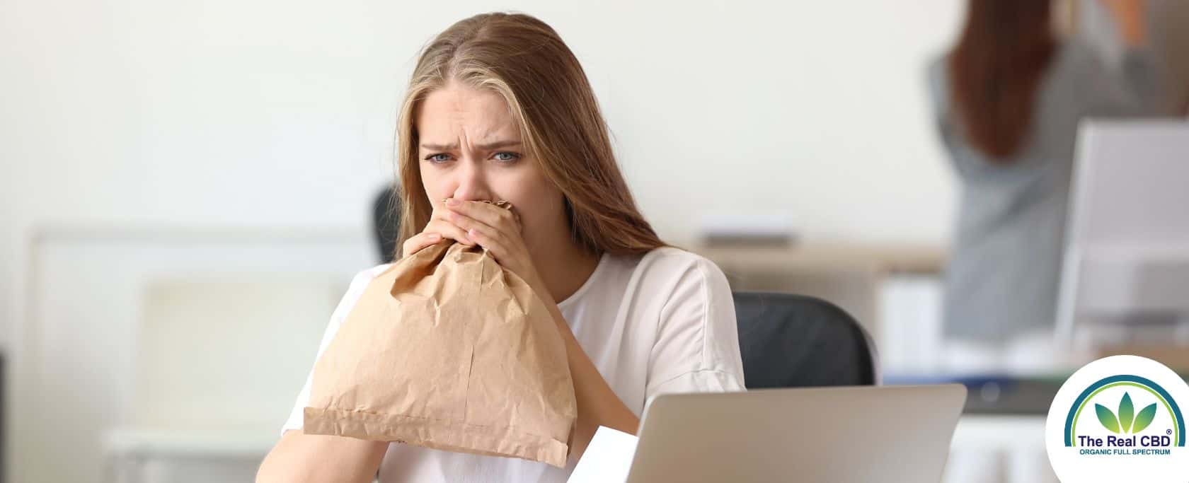 Femme soufflant dans un sac en papier dans un bureau