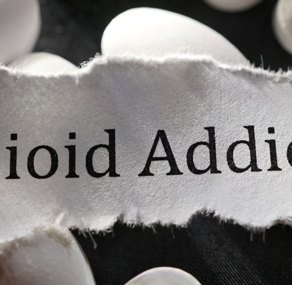 Opioid Addiction on a white paper rip onto of white pills