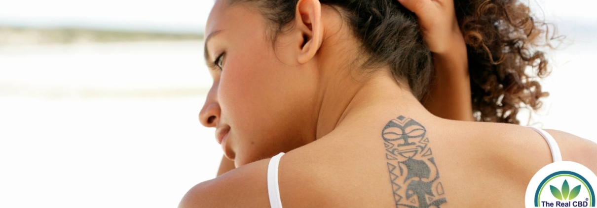 Woman lifting her hair to reveal a tattoo