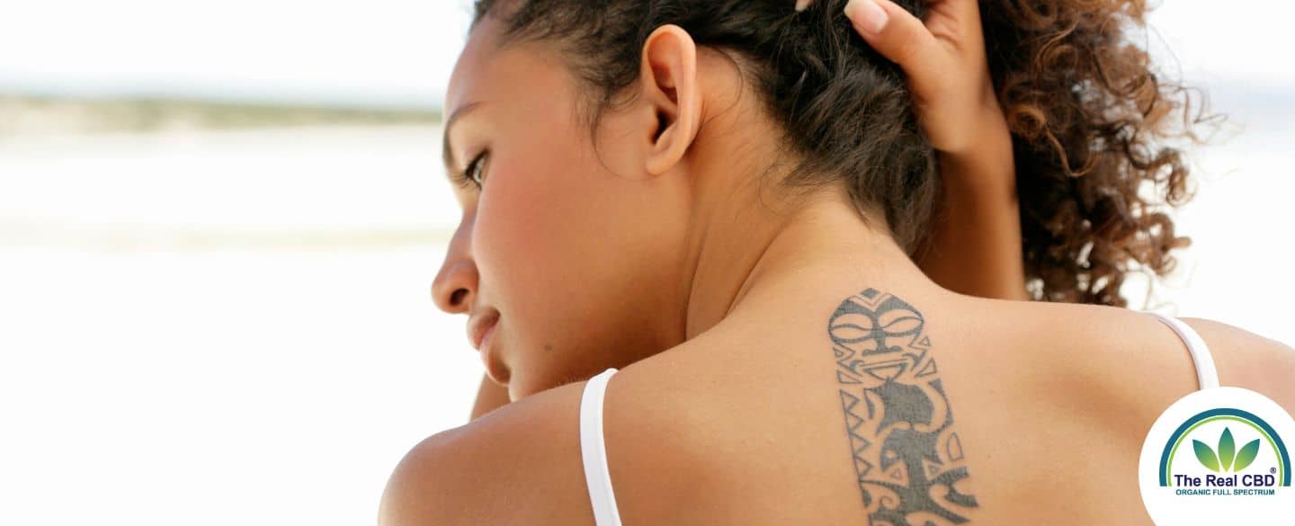 Woman lifting her hair to reveal a tattoo