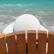 Femme assise sur une chaise de plage au bord de la mer, en train de se détendre