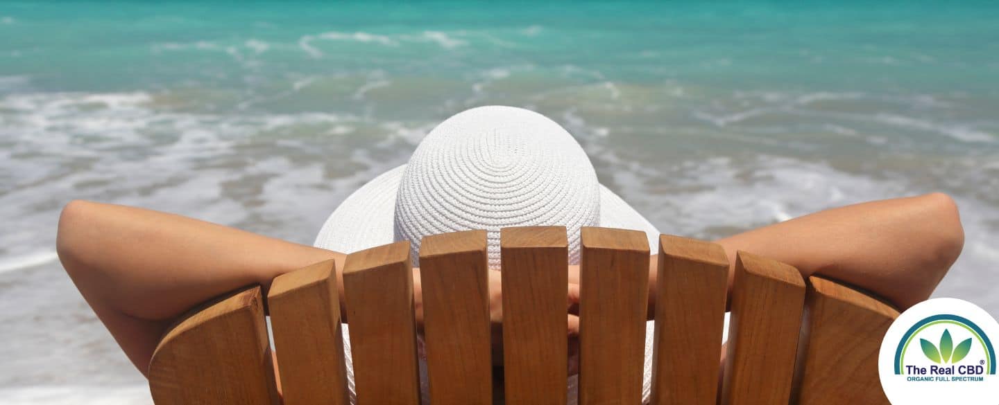 Femme assise sur une chaise de plage au bord de la mer, en train de se détendre