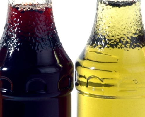 Different coloured liquid in bottles in a line