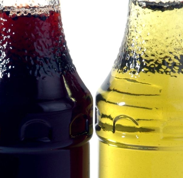 Different coloured liquid in bottles in a line