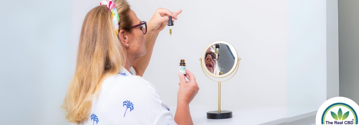 Woman in front of a mirror taking CBD oil