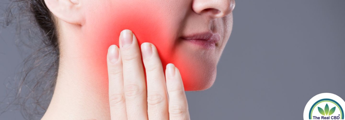 Woman holding cheek in tooth pain