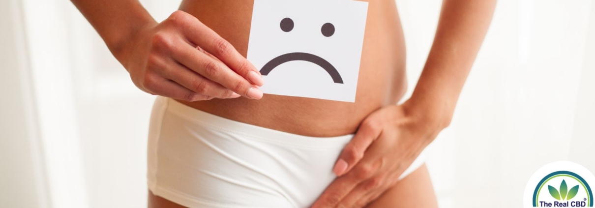 Woman holding an unhappy sign in front of her pelvis