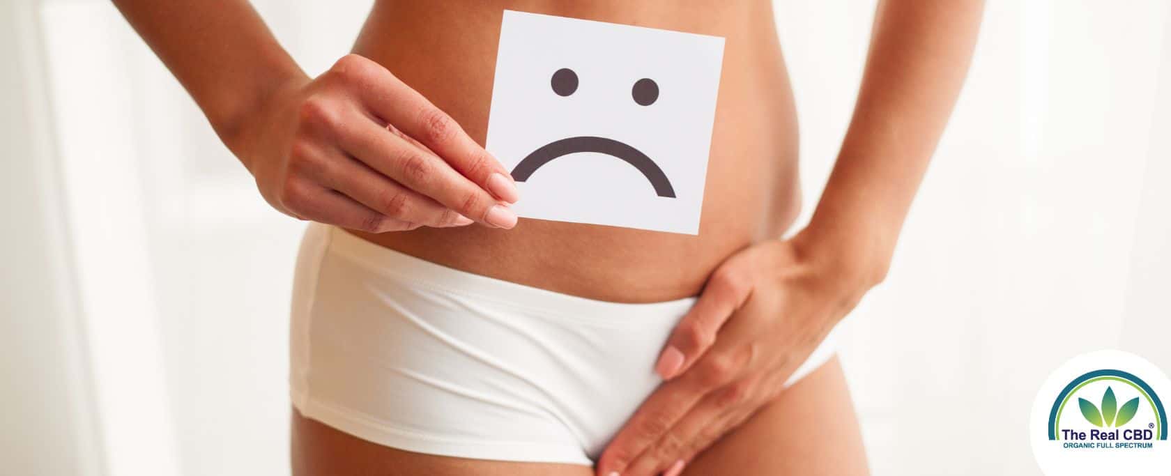 Woman holding an unhappy sign in front of her pelvis