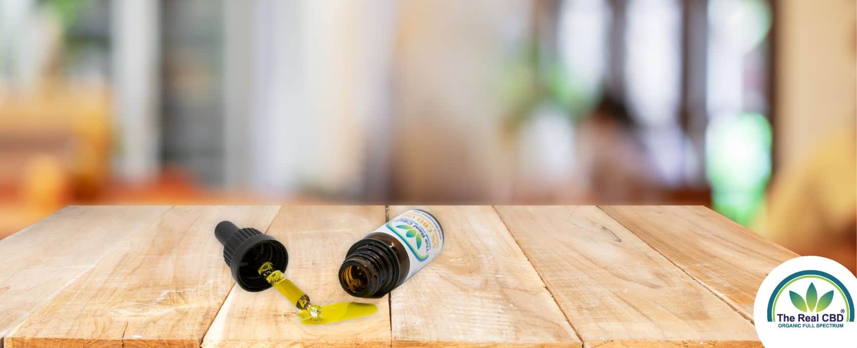 Tipped over CBD bottle with oil running out in focus.