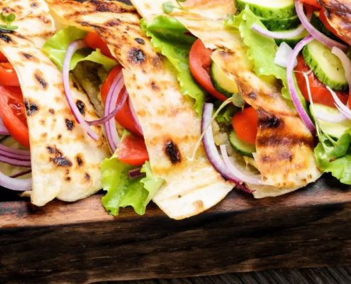 Pita bread sandwiches on a wooden tray