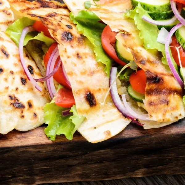 Pita bread sandwiches on a wooden tray