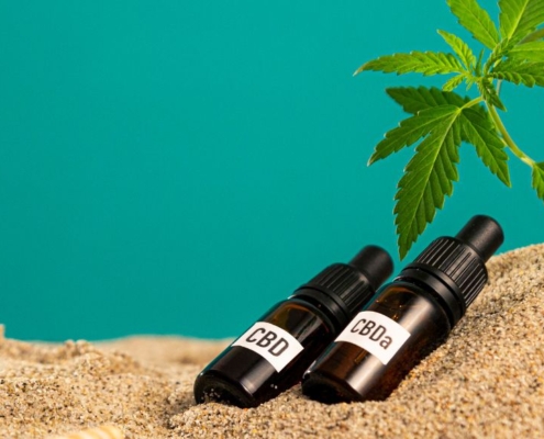 CBD- und CBA-Ölflaschen im Sand